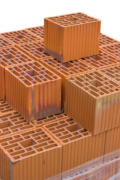 Bloc d'argile creux orange empilé pour la construction de bâtiments
 - Photo, image