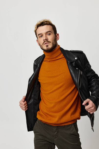 μοντέρνα ανδρική μάρκα ρούχα δερμάτινο μπουφάν πορτοκαλί πουλόβερ παντελόνι - Φωτογραφία, εικόνα