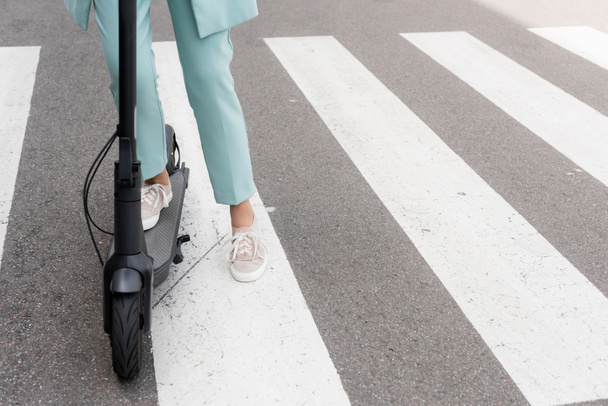 Vista recortada de la mujer de negocios de pie en scooter patada eléctrica  - Foto, Imagen