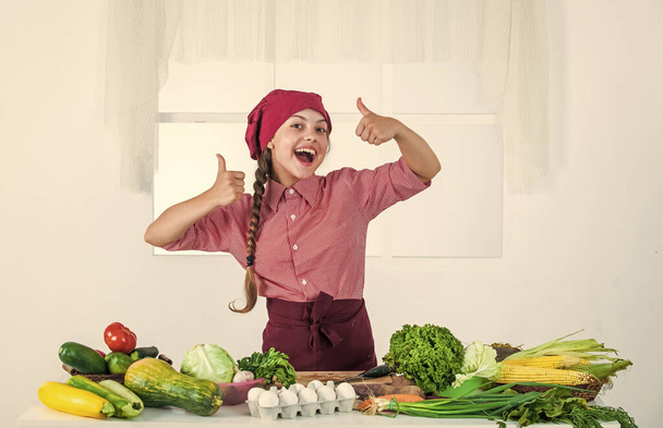 smiling teen girl in chef uniform cooking vegetables, grocery - Foto, imagen