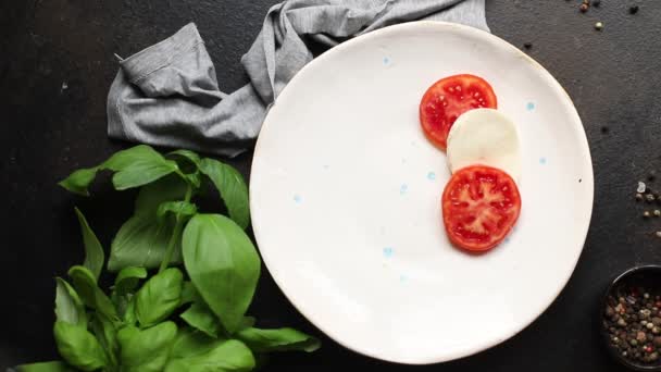 カプレーゼサラダモッツァレラチーズトマトバジルの葉イタリアのスナックコピースペースフード背景素朴な。トップビューケトかパレオ・ディエット・ベジタリアン・フード - 映像、動画