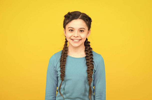 happy childrens day. beautiful braided long hair. stylish braids and pigtails. cute teenage girl. professional hairdo. kid fashion and beauty. small girl after hairdresser salon. childhood happiness - Photo, Image