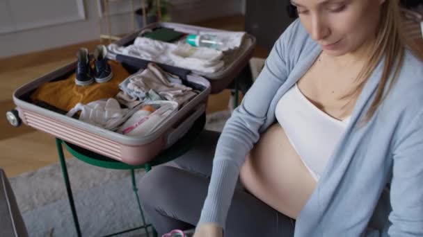 Donna incinta che fa le valigie all'ospedale. Girato con telecamera ad elio rosso in 8K - Filmati, video