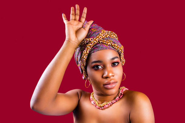 zanzibar woman with headwear in red studio wall background - Fotó, kép