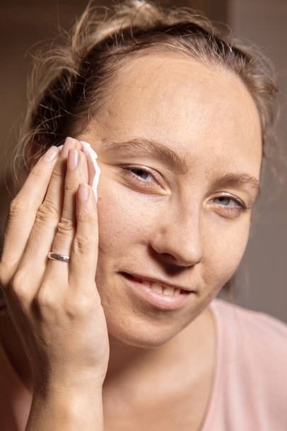 Щоденні процедури догляду за шкірою обличчя. Жінка з пост-акне використовує тонер і вату. Взято впритул. Вибірковий фокус
 - Фото, зображення