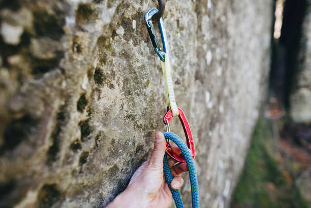 Nahaufnahme von Bergsteiger Hand Clipping Seil in einem Schnellzug Karibener auf einer Felswand - Foto, Bild