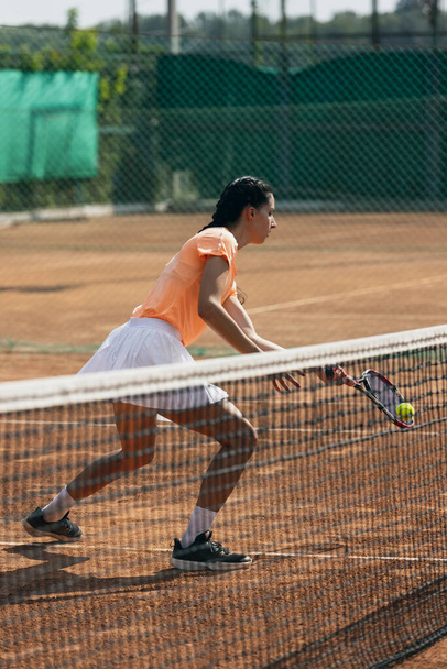Красива молода спортсменка, професійний тенісист з ракеткою, що практикує глиняний тенісний корт в літній день
. - Фото, зображення