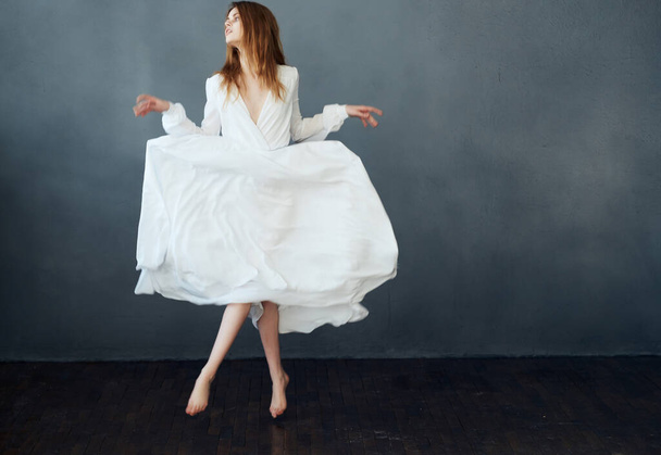Woman in white dress dancing on  dark background. High quality photo - Photo, Image