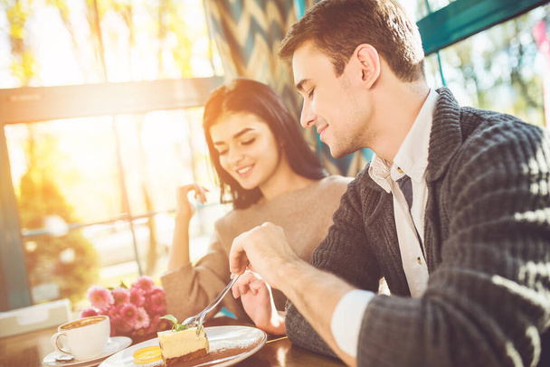 A boldog férfi és nő eszik a desszertet a kávézóban. - Fotó, kép