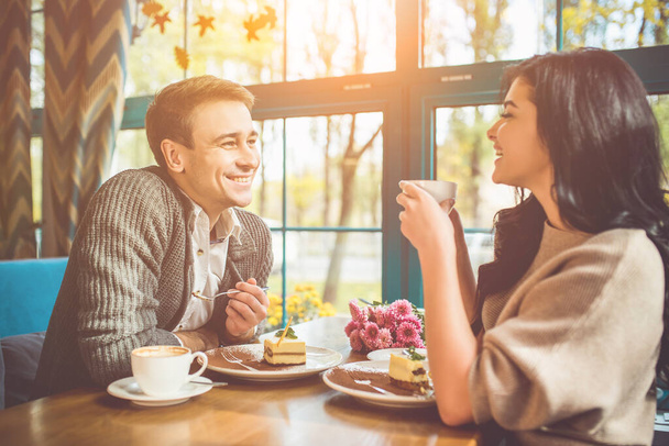 A boldog férfi és nő tortát eszik a kávézóban. - Fotó, kép