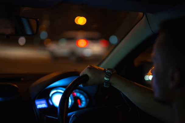 Az az ember autót vezet éjszaka. Baloldali forgalom - Fotó, kép