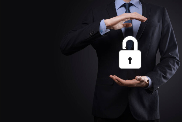 Businessman holds an open padlock icon on his palm.unlocking a virtual lock. Business concept and technology metaphor for cyber attack, computer crime, information security and data encryption - Foto, imagen