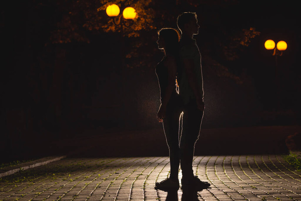 Мужчина и женщина стоят на темной улице. ночь время - Фото, изображение