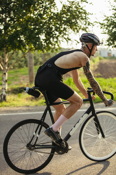 Молодой велосипедист катается на дорожном велосипеде в летний день. Действие, концепция движения - Фото, изображение