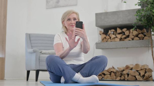 Stará žena pomocí Smartphone na cvičení matice doma - Fotografie, Obrázek