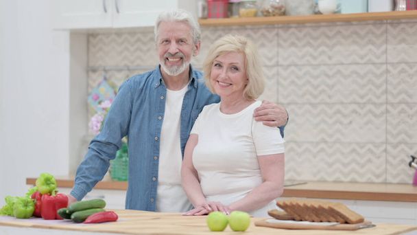 Vecchio coppia sorridente a camera in cucina  - Foto, immagini