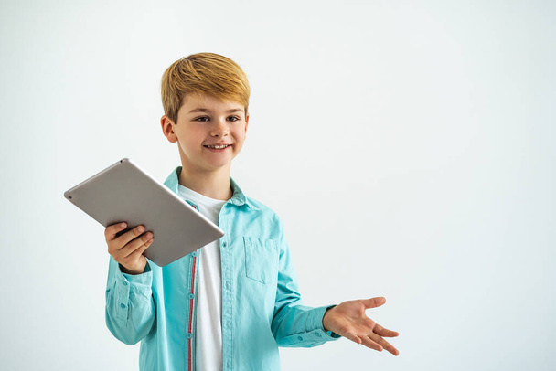 De gelukkige jongen met een tablet op de witte achtergrond - Foto, afbeelding