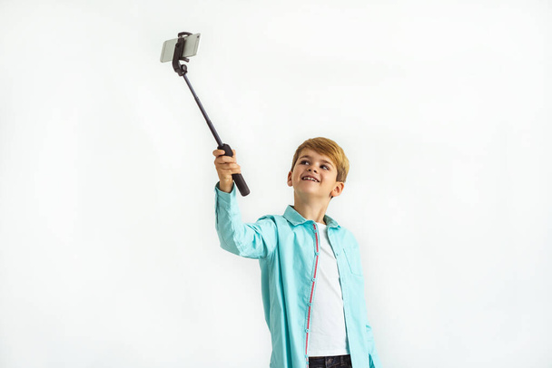 Le garçon heureux prenant un selfie sur le fond blanc - Photo, image