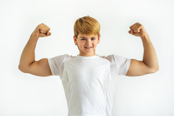The happy boy standing ahead the muscular man on the white background - Foto, imagen