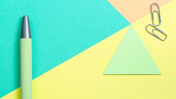 Multi colored geometric background with Green pen and paper clips. High quality photo - Fotó, kép