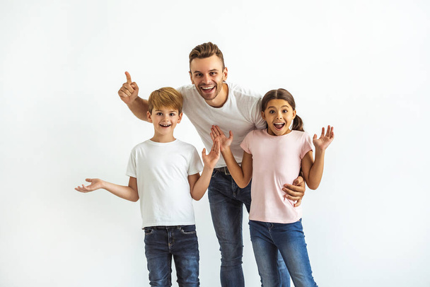 De gelukkige vader en kinderen gebaren op de witte achtergrond - Foto, afbeelding