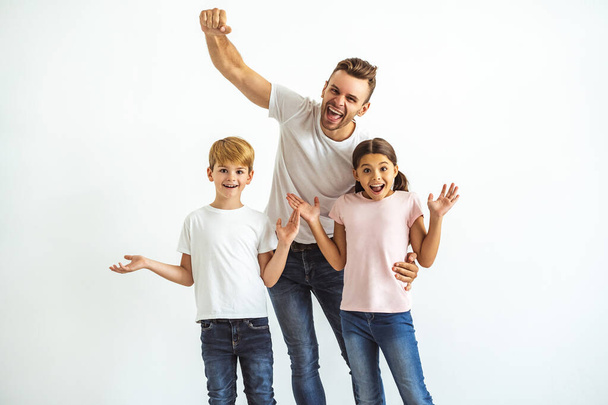 The happy father and kids gesturing on the white background - Фото, изображение