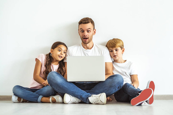 Vater und Kinder mit Laptop auf dem Fußboden - Foto, Bild