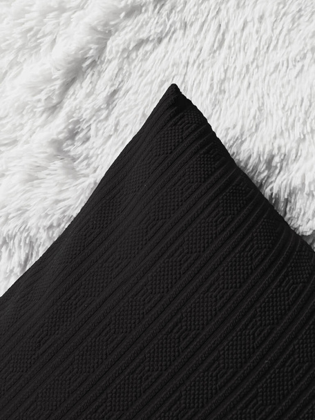 Almohada de lanzamiento de cojín negro sobre manta a cuadros esponjosa blanca como fondo plano, vista superior del dormitorio y decoración del hogar - Foto, Imagen