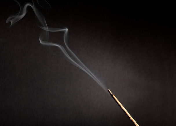 Bastone incenso con fumo su sfondo nero
 - Foto, immagini