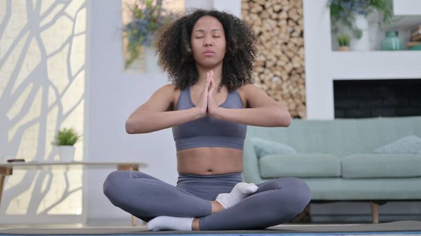 Mladá africká žena medituje na cvičení Mat doma - Fotografie, Obrázek