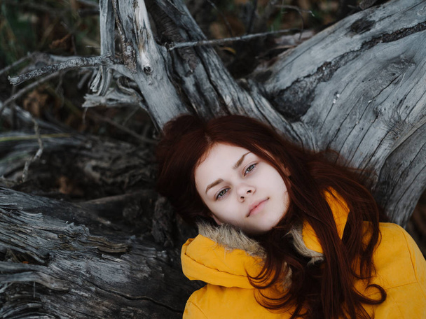 red-haired woman in a yellow jacket on the nature autumn forest - Фото, зображення