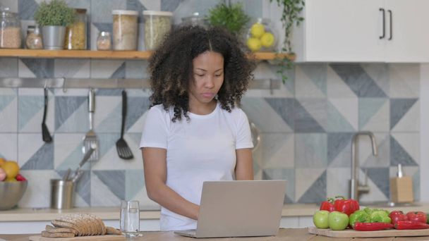 Młoda Afrykanka pracuje na laptopie w kuchni - Zdjęcie, obraz