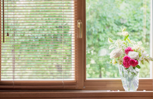 summer bouquet in glass vase  on windowsill in wooden house - Фото, изображение