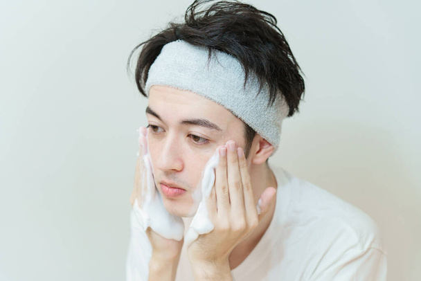 Asiático joven hombre lavado su cara - Foto, Imagen
