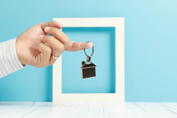 ビジネスマンの手を握っている家の鍵チェーン、不動産と不動産 - 写真・画像
