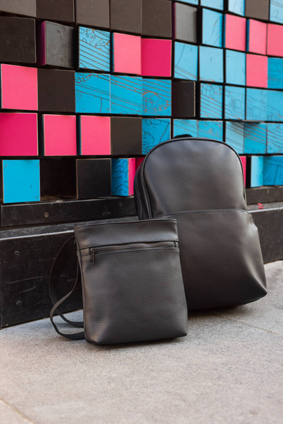 Set de mochila y mensajero cerca de colorida pared - Foto, imagen
