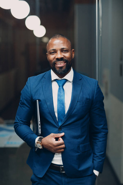 Πορτρέτο χαμογελαστός Αφροαμερικανός επιχειρηματίας με μπλε κοστούμι στο γραφείο - Φωτογραφία, εικόνα