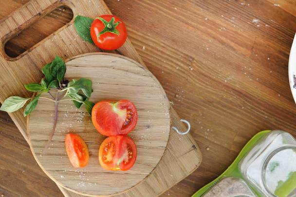 Спелые органические помидоры в миске на деревянном столе, плоский вид сверху, копия пространства для текстового шаблона - Фото, изображение
