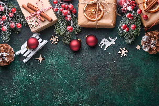 クリスマスモミの木の枝、クリスマスボール、ギフトボックス、木製の雪片とあなたのクリスマスの挨拶のための緑の具体的な石の背景の星。コピースペース付きのトップビュー。クリスマスグリーティングカード. - 写真・画像