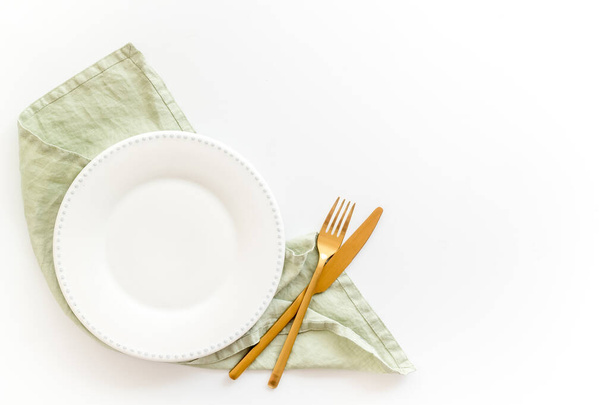 Empty tableware with tablecloth top view. Plate with fork and knife on napkin - Photo, Image