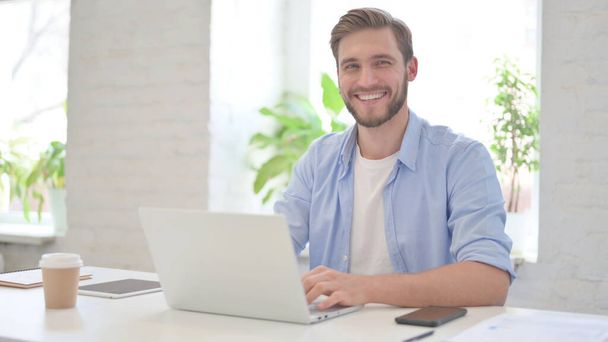 Young Man with Laptop Smiling at Camera  - Photo, Image