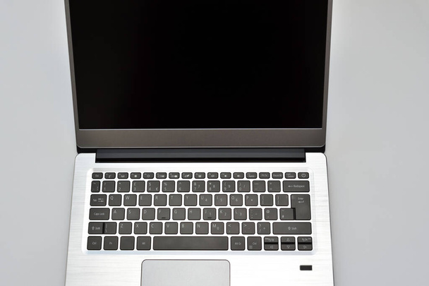 Ноутбук с черным экраном, сенсорной панелью и клавиатурой для записи текста. Ноутбук для удаленной работы, видеоконференции и чата в Интернете. - Фото, изображение