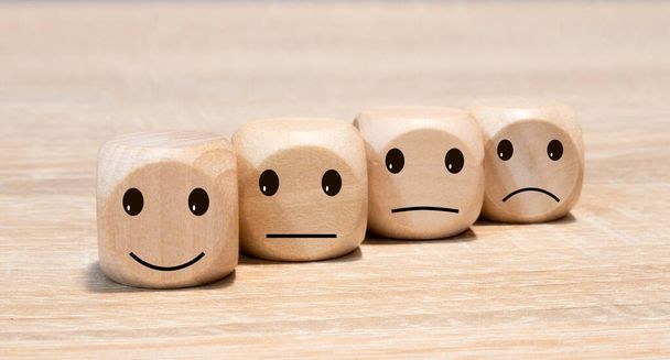 Emoticons with different whims on three wooden cubes. - Photo, Image