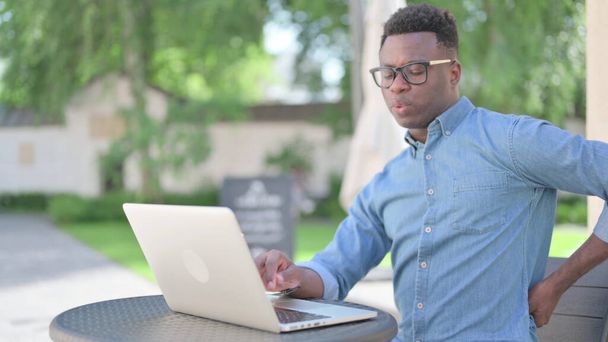 African Man with Laptop having Back Pain Sitting Outdoor - Foto, immagini