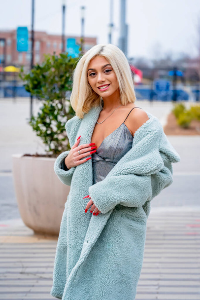 Ein hinreißendes junges blondes Model posiert im Freien und genießt einen Wintertag - Foto, Bild