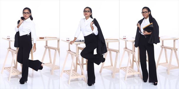 Full length body portrait of 20s Asian Woman φορέστε επαγγελματικό πουκάμισο σε μαύρο λευκό. Μαύρο κορίτσι του δέρματος σταθεί εκφράζουν αίσθηση ισχυρή αυτοπεποίθηση πάνω από το γραφείο ξύλινο τραπέζι λευκό φόντο απομονωμένο - Φωτογραφία, εικόνα