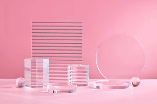 Glass Geometric podium for product display. Monochrome platform with ribbed acrylic sheets and crystal triangle on pink background. Stylish background for presentation. Minimal style - Fotó, kép