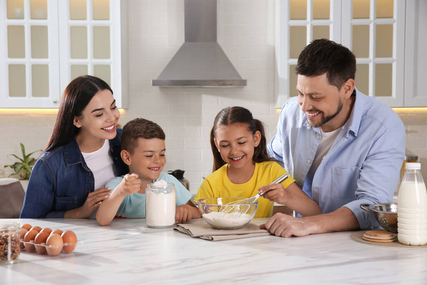 Happy family cooking together at table in kitchen. Adoption concept - Fotoğraf, Görsel
