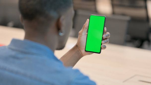 Afrikaner hält Smartphone mit grünem Bildschirm - Foto, Bild
