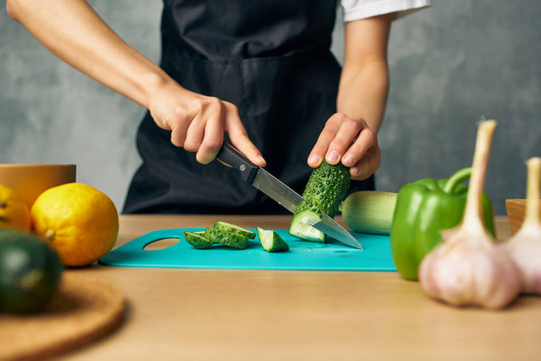 Woman in black apron Cooking healthy eating cutting board - Φωτογραφία, εικόνα